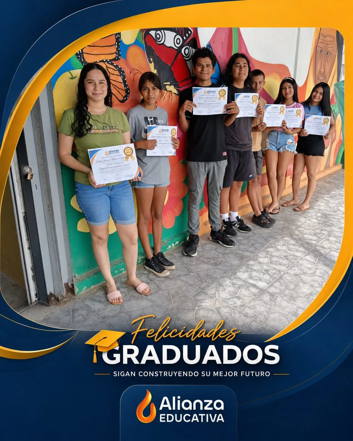 Estudiantes graduados frente a mural de colores con sus diplomas